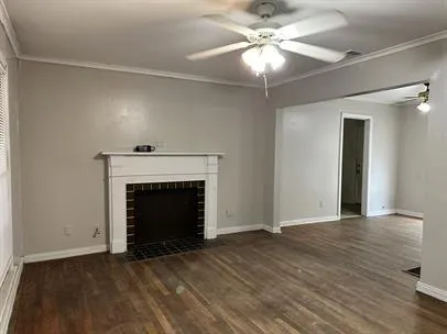 a view of empty room with fireplace and wooden floor