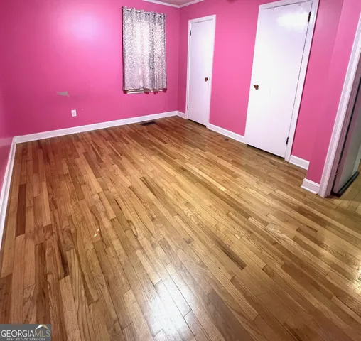 a view of a room with wooden floor and windows