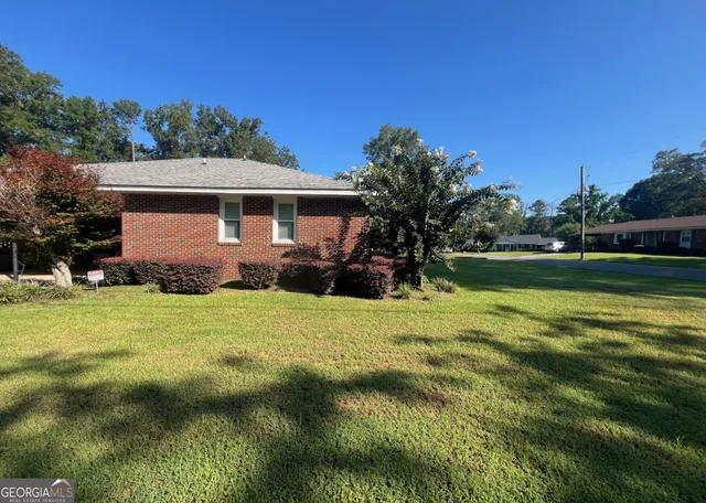 a front view of house with garden and swimming pool