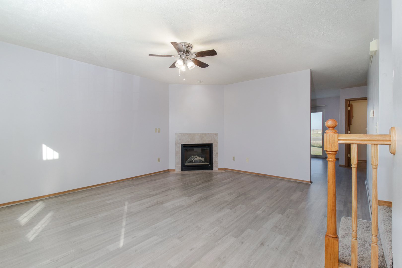 2 Andy Court, Unit 3 Bloomington, IL 61704 - Photo 2 of 28 a view of an empty room with wooden floor and a fireplace