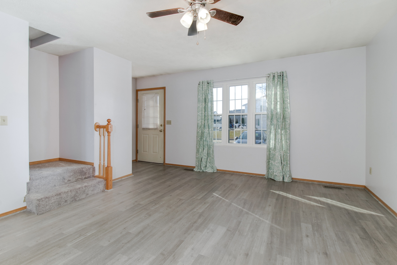 2 Andy Court, Unit 3 Bloomington, IL 61704 - Photo 4 of 28 an empty room with chandelier fan and windows