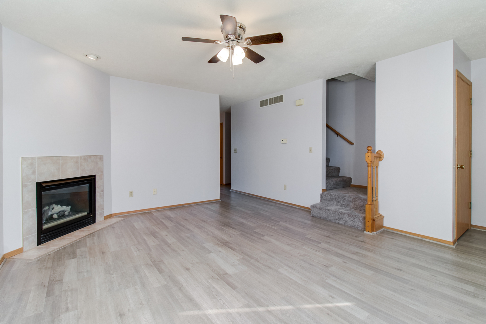 2 Andy Court, Unit 3 Bloomington, IL 61704 - Photo 5 of 28 a view of empty room with wooden floor and fan