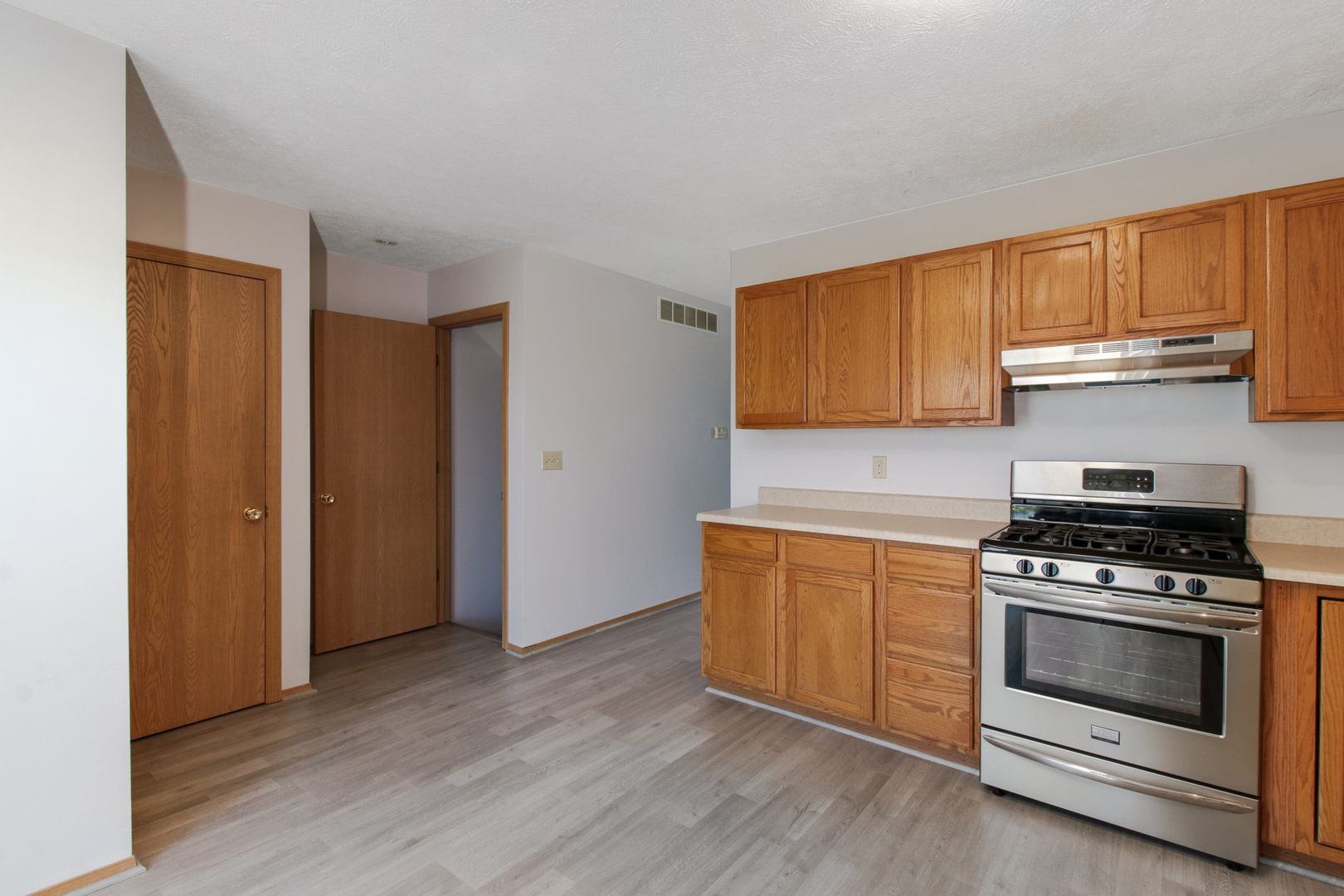 2 Andy Court, Unit 3 Bloomington, IL 61704 - Photo 9 of 28 a kitchen with granite countertop wooden floors and stainless steel appliances