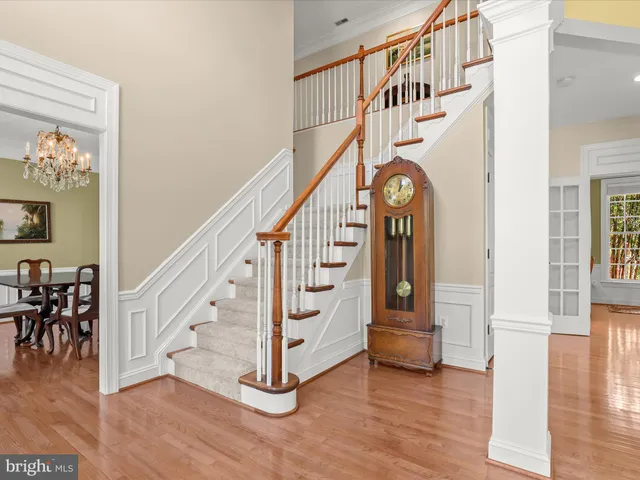 a kitchen with stainless steel appliances granite countertop a refrigerator a stove a sink a dining table and chairs with wooden floor