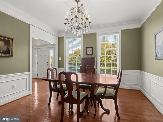 a kitchen with stainless steel appliances granite countertop a table chairs sink refrigerator and microwave