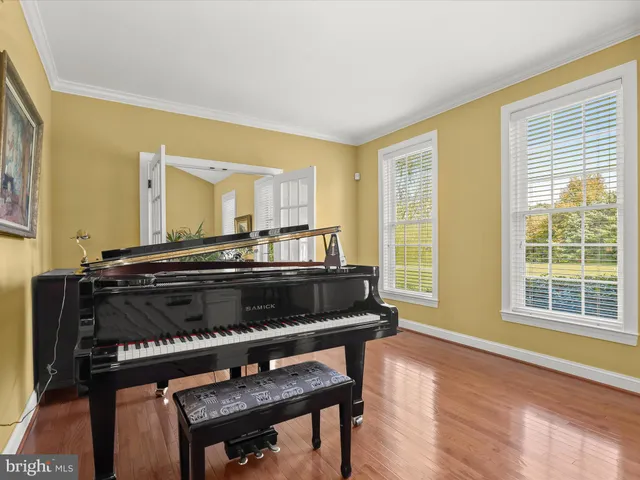 a view of staircase with lots of frames and frames on wall and wooden floor
