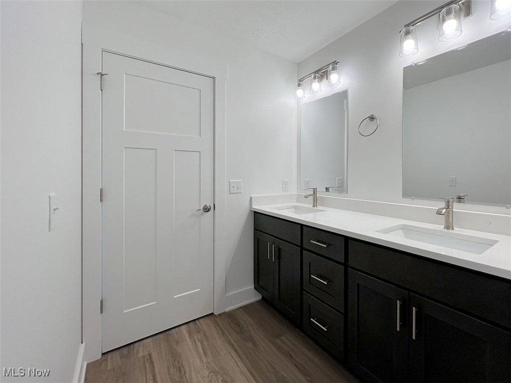 3641 Menlo Road Cleveland, OH 44120 - Photo 14 of 26 Bathroom featuring double vanity with quartz countertops, mirrors, lighting and wood finished floors