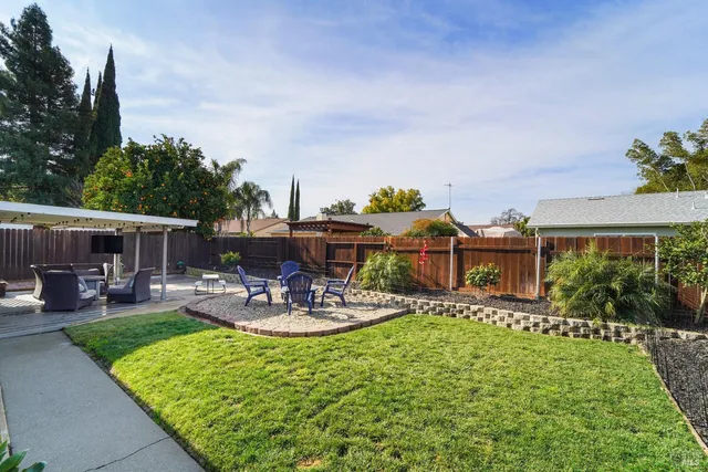 a view of a house with backyard sitting area and garden