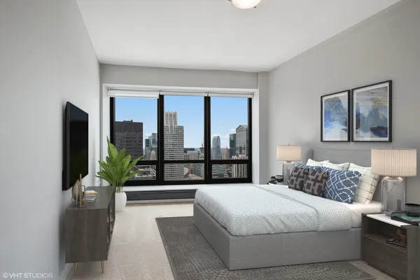 a bedroom with a large bed and a potted plant