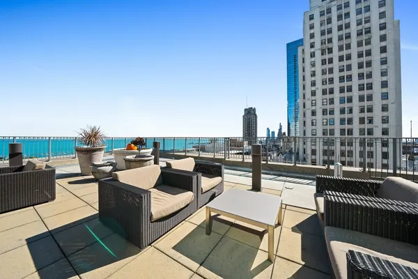 a view of a roof deck with couches and potted plants