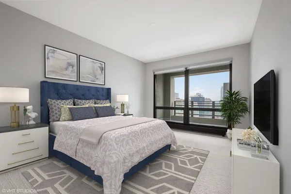 a bedroom with a large bed and a flat tv screen on dresser