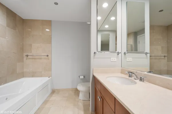 a bathroom with a granite countertop sink a toilet and bathtub