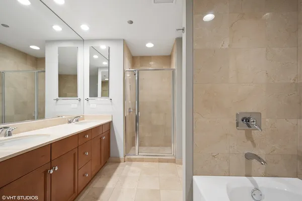 a bathroom with a double vanity sink mirror and shower