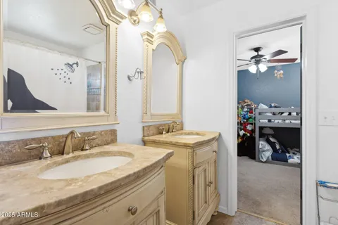 a en suite bathroom with a granite countertop sink and a mirror