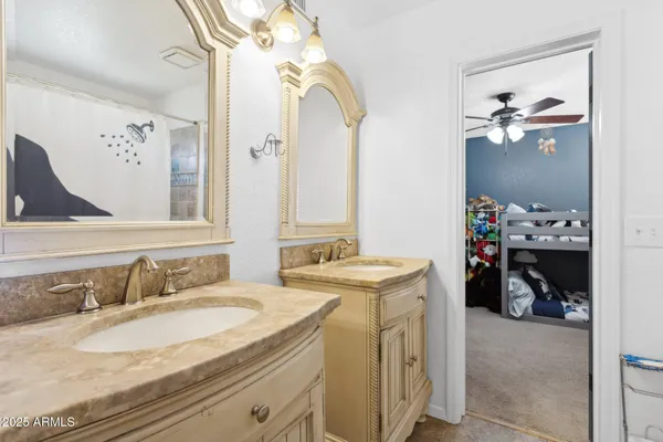 a en suite bathroom with a granite countertop sink and a mirror