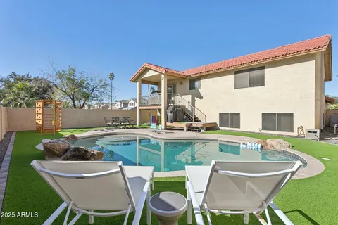 a view of a house with pool and chairs