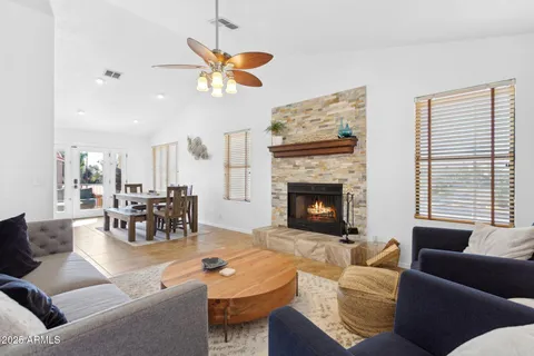 a living room with furniture a fireplace and a chandelier
