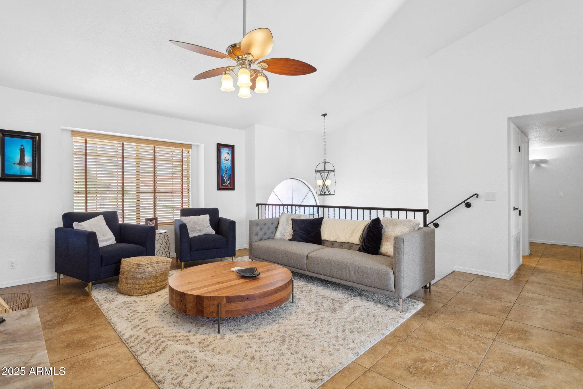 1255 West Sea Shell Drive Gilbert, AZ 85233 - Photo 5 of 34 a living room with furniture a rug and a chandelier