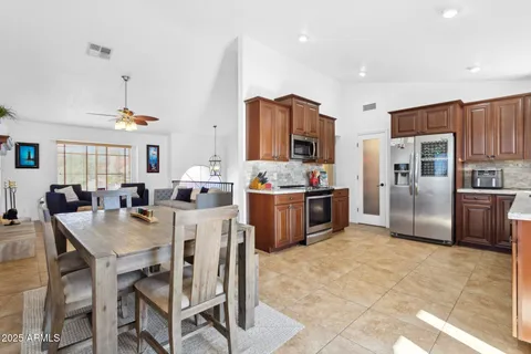 a large kitchen with sink a refrigerator and chairs