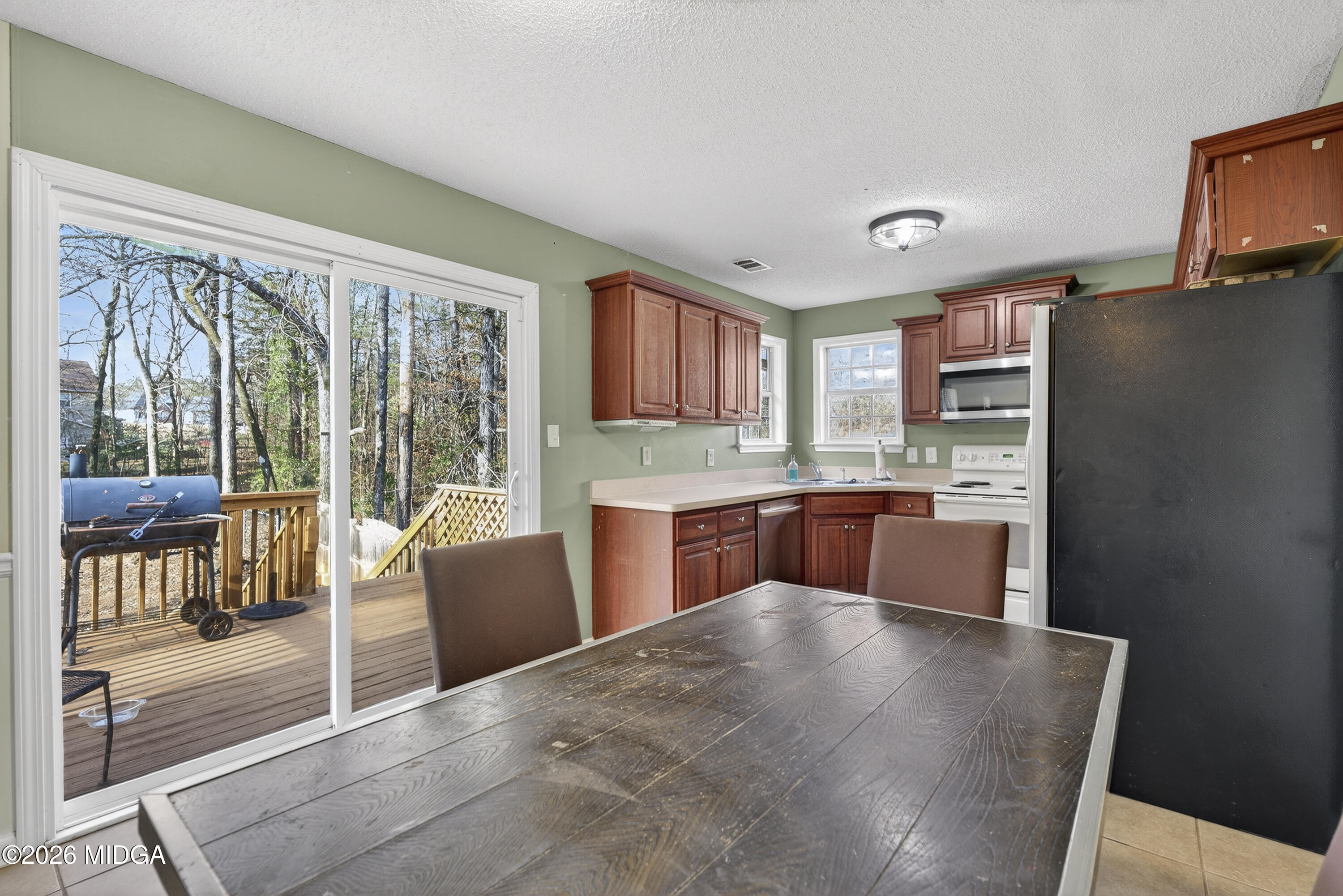 226 Amy Lane Gray, GA 31032 - Photo 15 of 46 a kitchen with stainless steel appliances kitchen island granite countertop a refrigerator a stove top oven and a view of living room