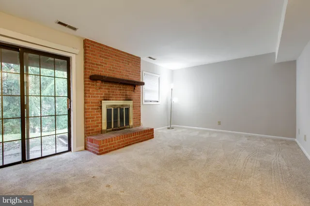 a view of an empty room with a fireplace and a window