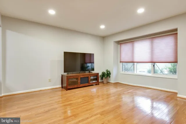 an empty room with windows flat screen tv and windows