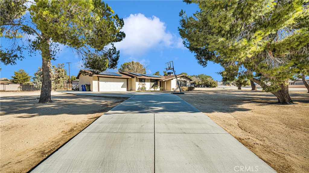 14176 Coachella Road Apple Valley, CA 92307 - Photo 1 of 1 a backyard of a house with lots of green space