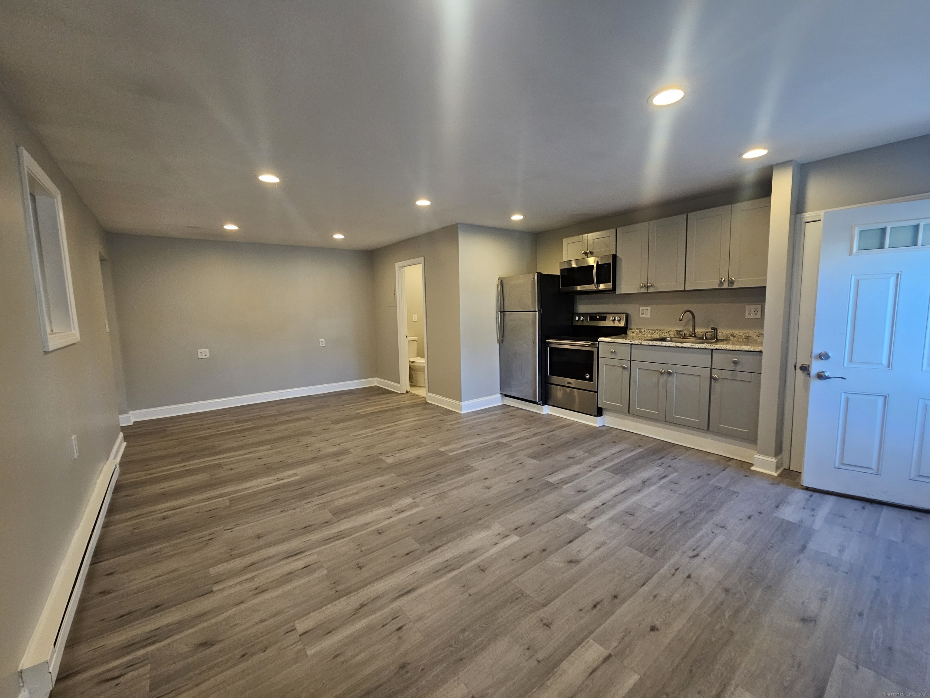370 Bruce Avenue Stratford, CT 06615 - Photo 2 of 6 an empty room with stainless steel appliances wooden floor and view living room