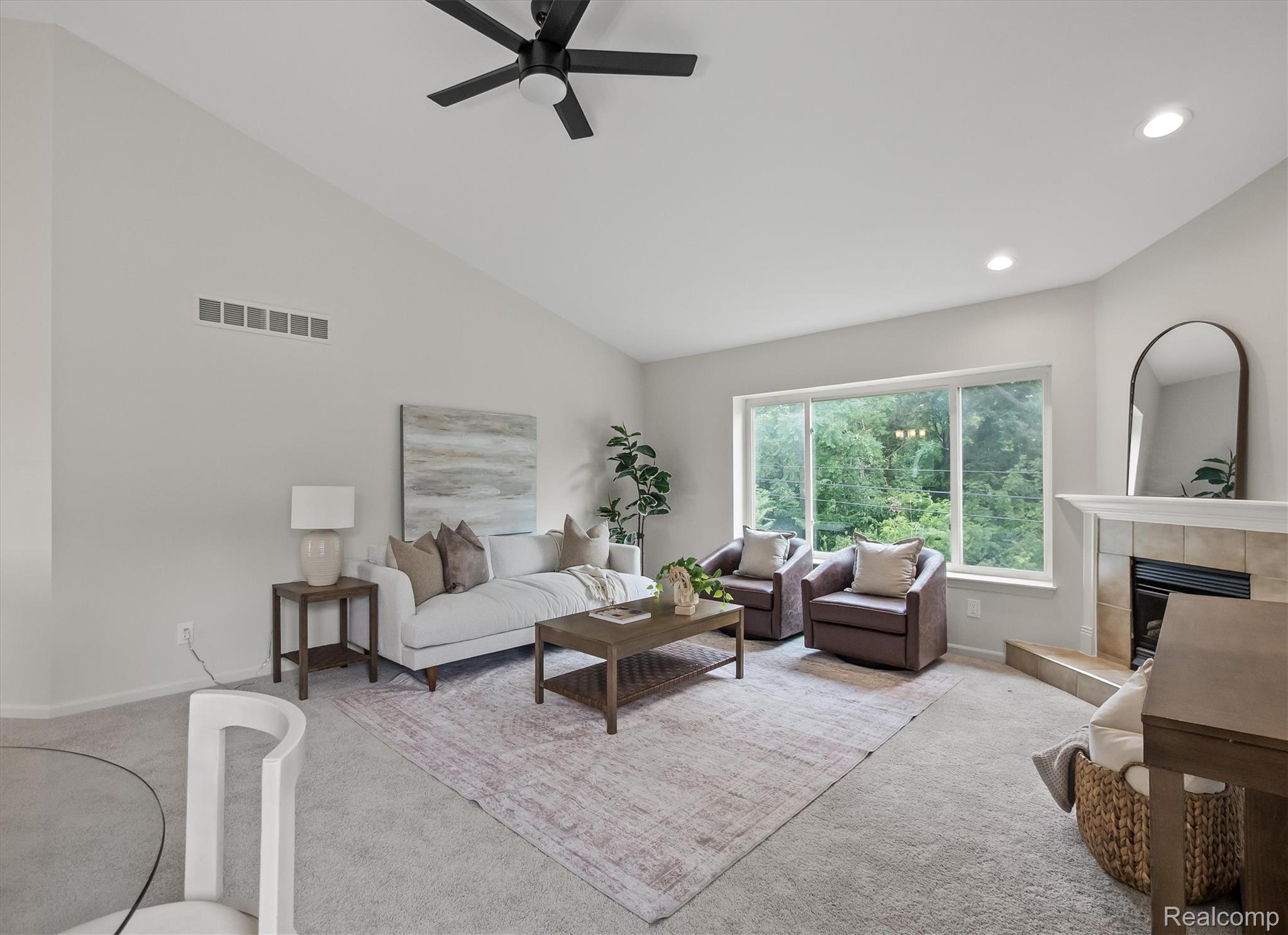Vaulted ceiling with a ceiling fan, recessed lighting, and a wide window