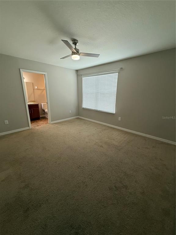 4656 Vignette Way Sarasota, FL 34240 - Photo 18 of 33 an empty room with a ceiling fan and windows