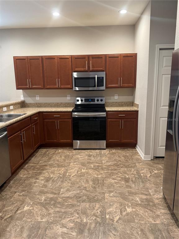 4656 Vignette Way Sarasota, FL 34240 - Photo 6 of 33 a kitchen with stainless steel appliances granite countertop a stove top oven a sink and a granite counter tops