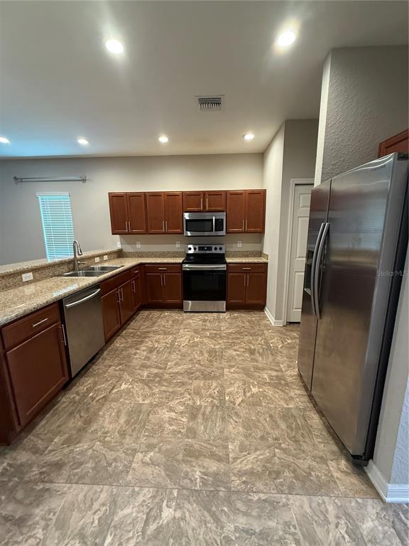 4656 Vignette Way Sarasota, FL 34240 - Photo 7 of 33 a kitchen with stainless steel appliances granite countertop a refrigerator and a sink