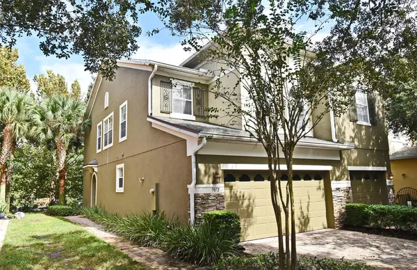 a front view of a house with a tree