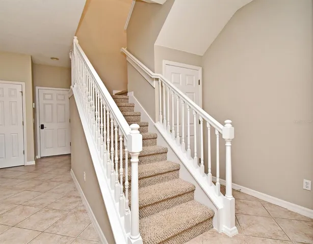 a view of staircase with railing and white walls