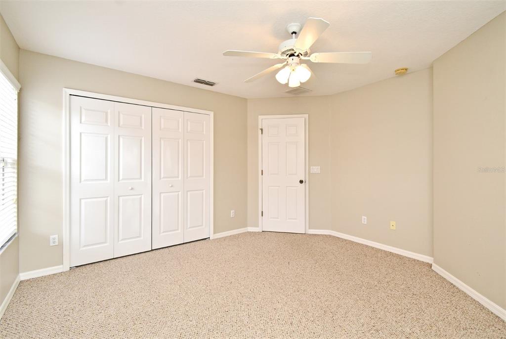 5072 Cypress Branch Point Oviedo, FL 32765 - Photo 18 of 23 an empty room with a chandelier fan and windows