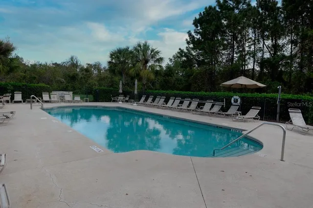 a view of a house with swimming pool and sitting area