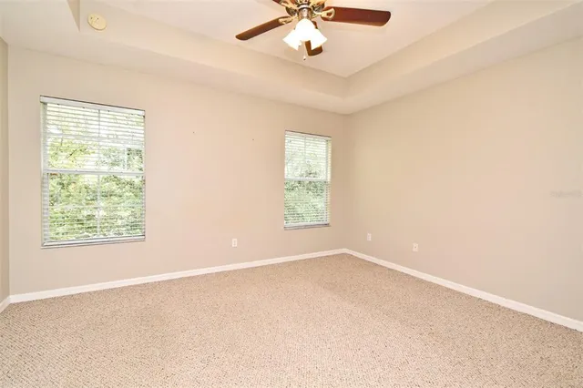 an empty room with a window and a fan