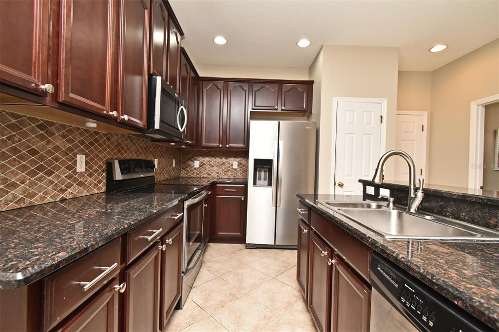 5072 Cypress Branch Point Oviedo, FL 32765 - Photo 7 of 23 a kitchen with stainless steel appliances granite countertop a sink a stove and a refrigerator