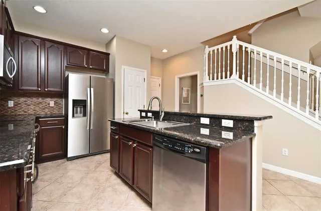 a kitchen with stainless steel appliances granite countertop a sink stove and refrigerator