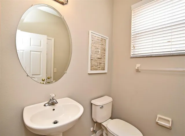 a bathroom with a toilet a sink and a mirror