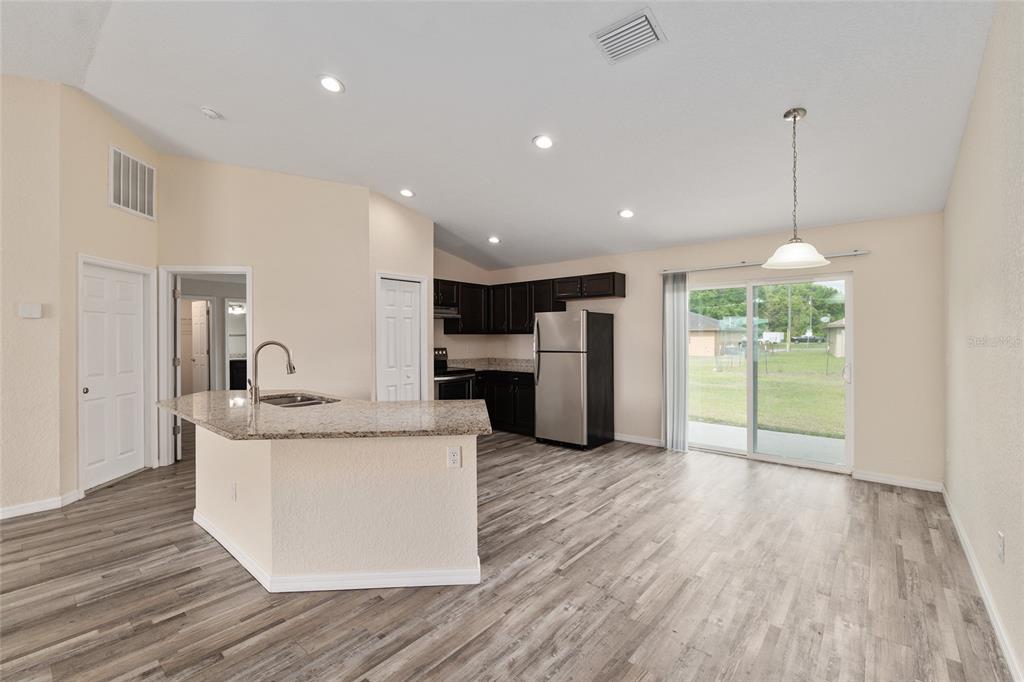22 Juniper Loop Circle Ocala, FL 34480 - Photo 19 of 53 a large white kitchen with a large island oven a stove and a wooden floors