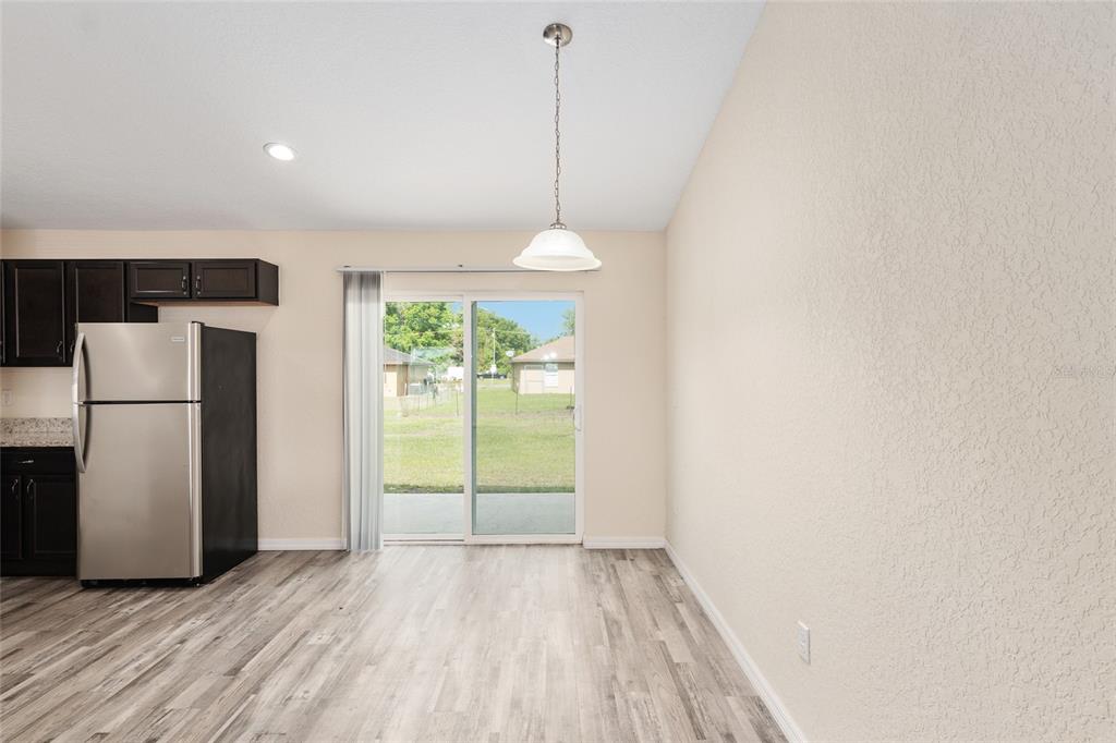 22 Juniper Loop Circle Ocala, FL 34480 - Photo 20 of 53 a view of a room with wooden floor and a refrigerator