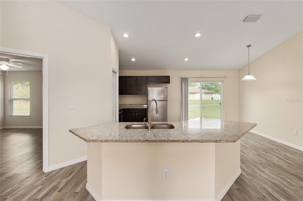 22 Juniper Loop Circle Ocala, FL 34480 - Photo 23 of 53 a kitchen with kitchen island granite countertop a sink and a granite counter tops