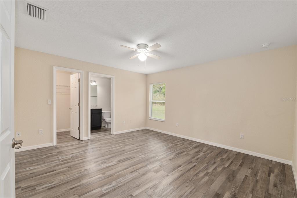 22 Juniper Loop Circle Ocala, FL 34480 - Photo 31 of 53 an empty room with wooden floor and a ceiling fan