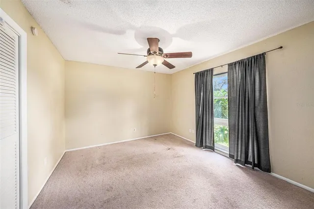 a view of a livingroom with a ceiling fan and window