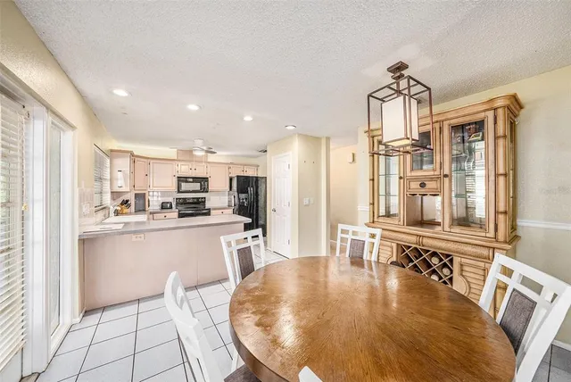 a kitchen with stainless steel appliances granite countertop a refrigerator a stove and white cabinets with wooden floors