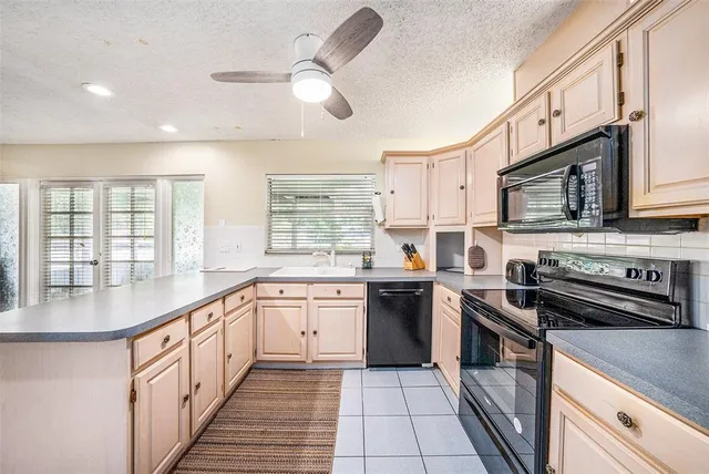a large kitchen with stainless steel appliances granite countertop a stove a sink and a microwave