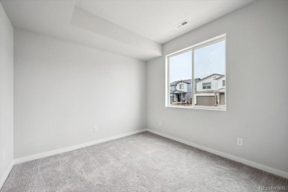 1382 Farmstead Street Brighton, CO 80601 - Photo 11 of 22 an empty room with windows and refrigerator