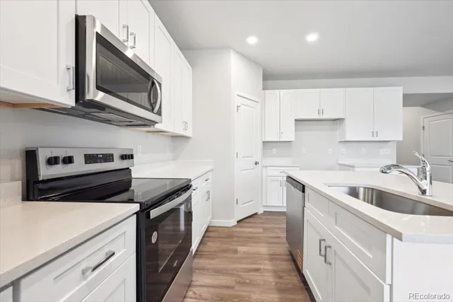 a kitchen with cabinets stainless steel appliances and a sink