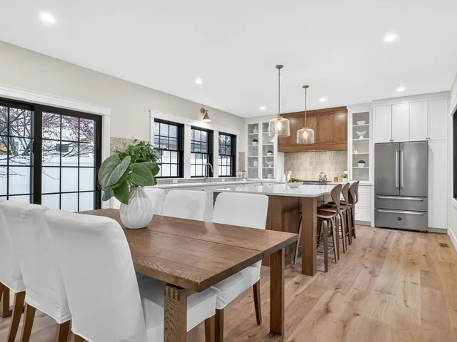 a kitchen with stainless steel appliances granite countertop a kitchen island a stove a table and chairs in it